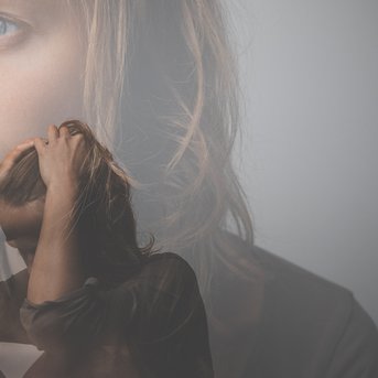 Eine Frau mit blauen Augen schaut nachdenklich, während eine andere Silhouette mit den Händen den Kopf stützt.