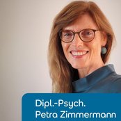 Diplom-Psychologin Petra Zimmermann lächelt in die Kamera, trägt eine blaue Bluse und hat lange, lockige Haare.